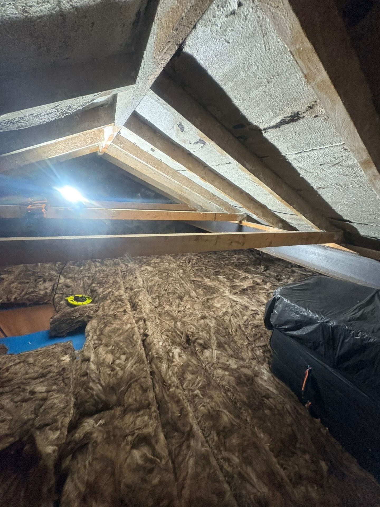 Closed cell spray foam applied tightly between rafters in a UK loft