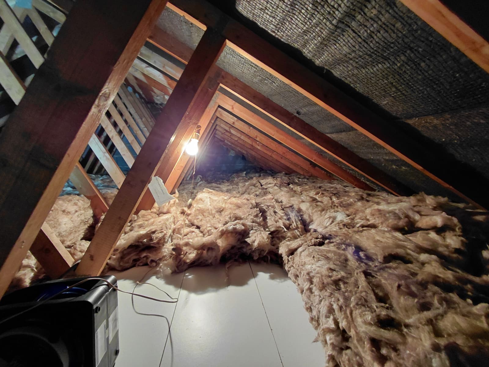 Loose mineral wool pulled back to inspect boarded section