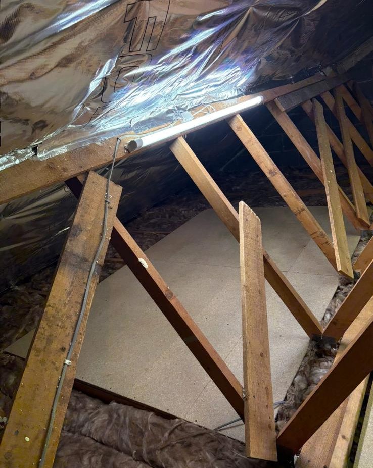 New loft boards installed beside foil-lined roof with task lighting