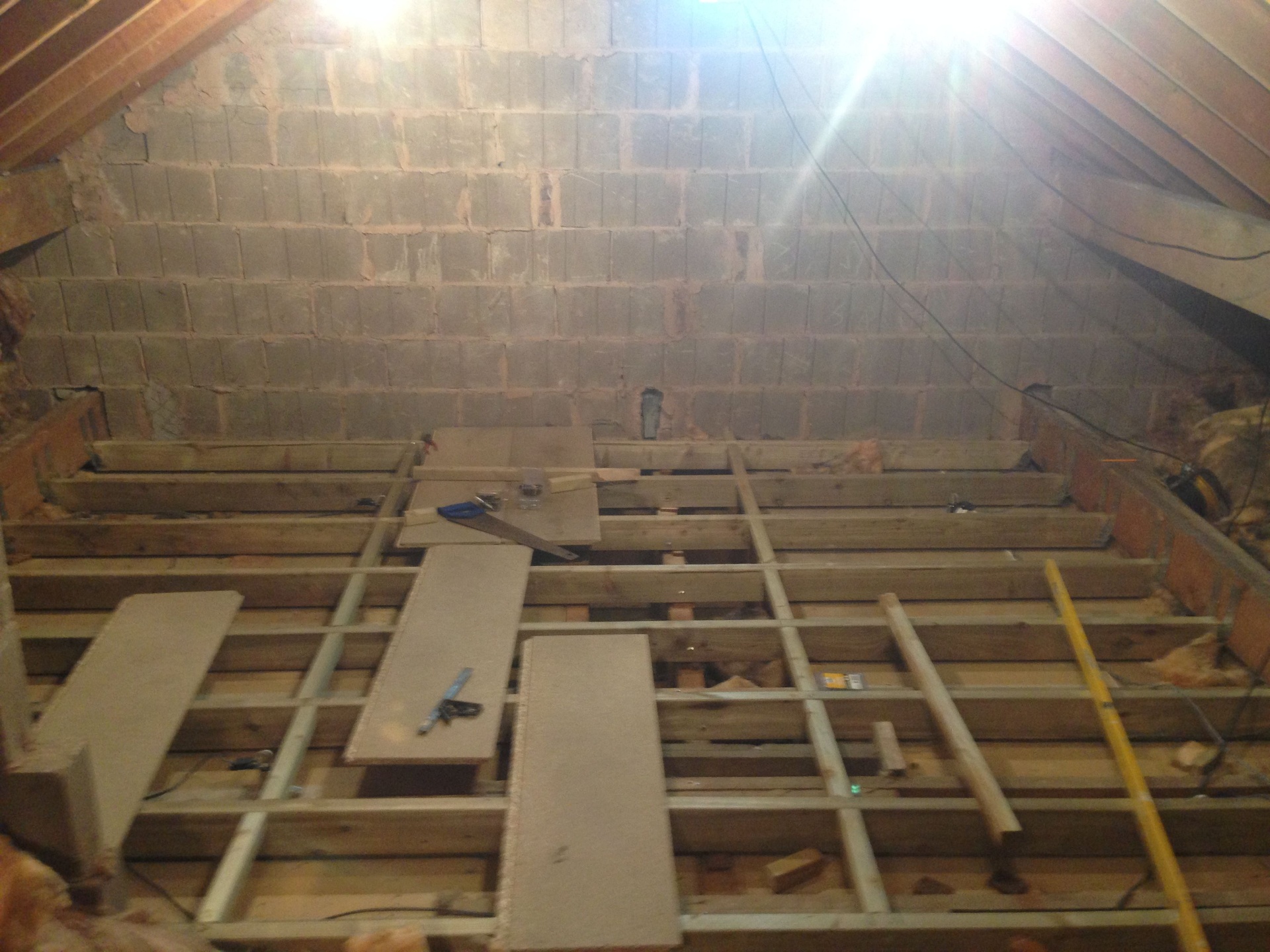 Loft after spray foam removal with cleaned rafters, mineral wool and boarded hatch